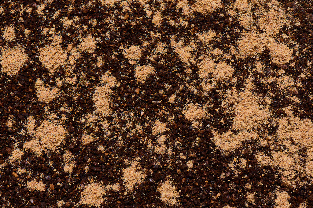Close up of chai spice seasoning sprinkled on coffee grounds