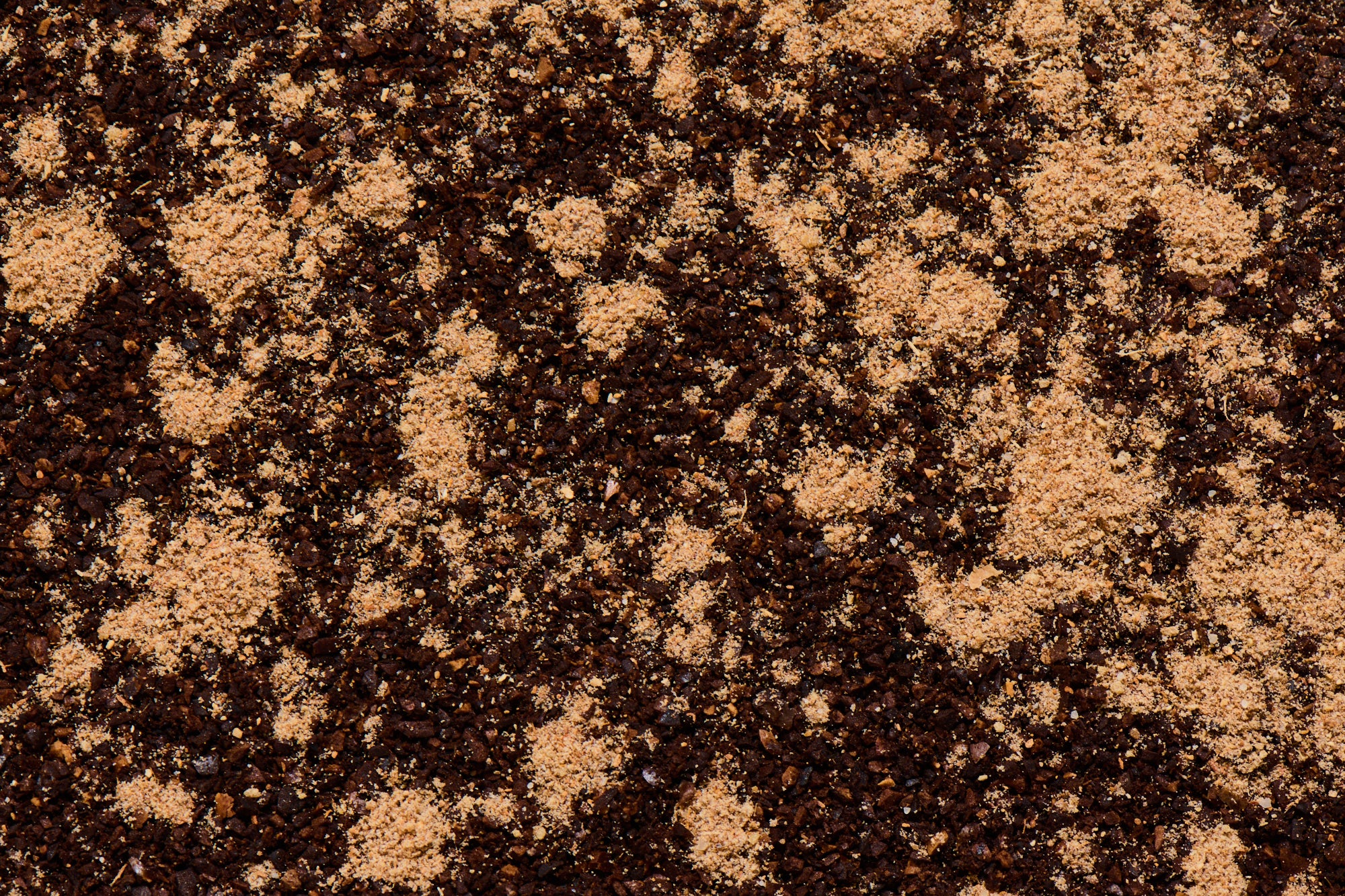 Close up of chai spice seasoning sprinkled on coffee grounds